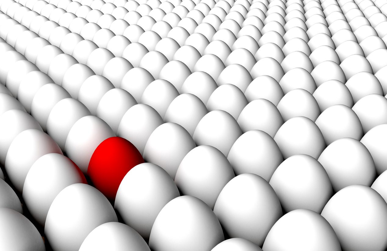 One red egg in a field of white eggs, illustrating anomaly detection.